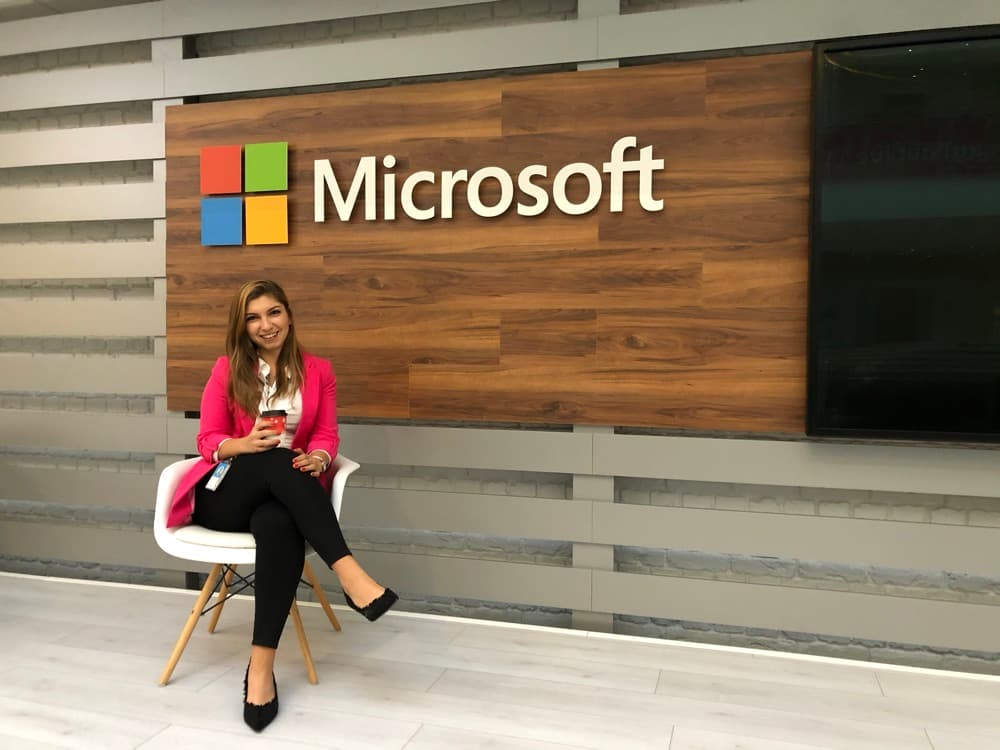 Ecem in front of a Microsoft sign at the office